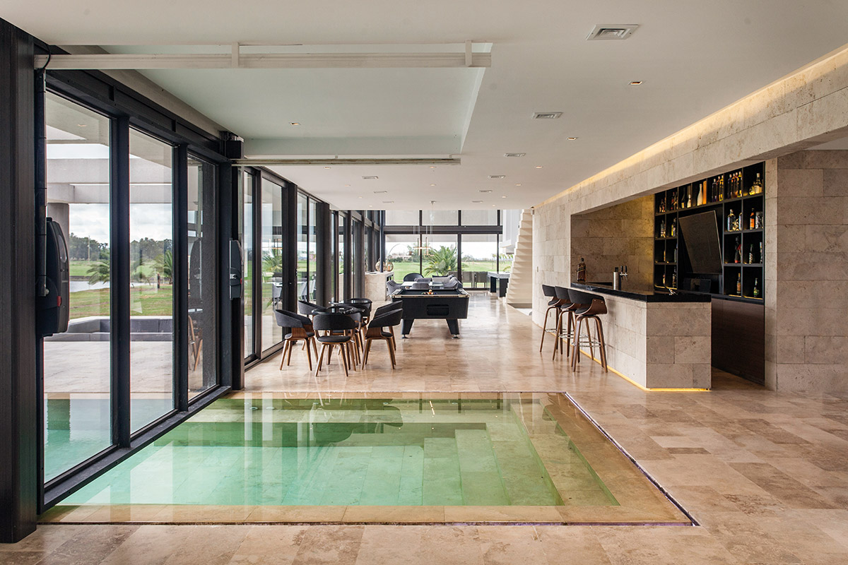 Abierto o cerrado, al enorme espacio integrado por pileta in/out, bar, pool y estar, no le falta nada. (OON Architecture)
